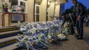 Des personnes déposent des fleurs le 16 octobre 2023 devant la cité scolaire Gambetta-Carnot d'Arras en hommage au professeur Dominique Bernard assassiné trois jours plus tôt