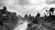 Des véhicules blindés américains sur une route bordée de ruines dans la ville de Saint-Lo, en 1944, pendant la Seconde Guerre mondiale