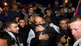 Un des prisonniers libérés, Bilal Abu Hussein, enlace ses proches à son arrivée dans Jerusalem Est, dans la nuit de lundi à mardi.