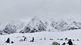 Des randonneurs dans la neige profonde au camp de Tangxiang, dans la vallée de Karma, dans la région autonome du Tibet, le 5 octobre 2025, après une forte chute de neige soudaine dans la région.