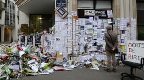 Des passants se rendent sur un mémorial dressé devant la rédaction de Charlie Hebdo, le 12 janvier 2015 à Paris. 