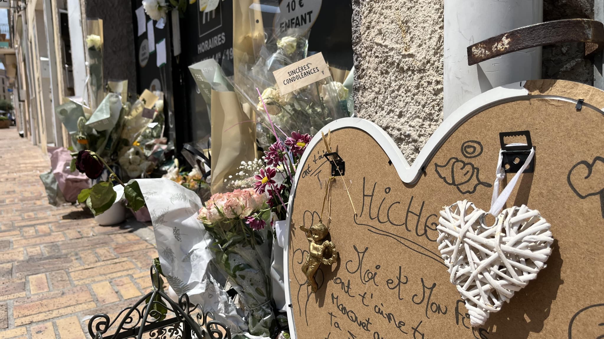 Des fleurs déposées en hommage au Tunisien Hichem Miraoui devant le salon de coiffure où il travaillait, le 3 juin 2025 à Puget-sur-Argens, dans le Var