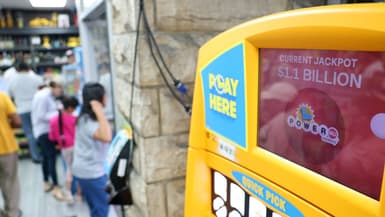 Une affiche indique un jackpot Powerball de 1,1 milliard de dollars alors que les gens font la queue pour acheter des billets avant le tirage du Labor Day au Bluebird Liquor Store à Hawthorne, en Californie, le 1er septembre 2025.