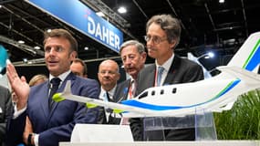 Le président français Emmanuel Macron se tient à côté d'un avion du projet Daher Ecopulse, un avion hybride à propulsion développé par Daher, Safran et Airbus, aux côtés du PDG de Safran, Olivier Andries, lors du Salon international du Bourget à l'aéroport de Paris-Le Bourget le 19 juin 2023.