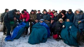L'Américain Michael Fossum, le Russe Sergueï Volkov et le Japonais Satoshi Furukawa, emmitouflés dans des couvertures après leur atterrissage à bord d'une capsule Soyouz mardi matin, pour leur retour après six mois passés à bord de la Station spatiale int