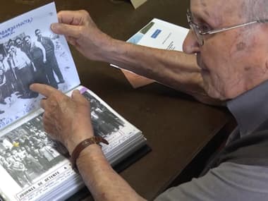 Albert Corrieri, ancien déporté âgé de 102 ans, montrant des photos de lui et ses camarades victime du STO durant la Seconde Guerre mondiale, en juin 2024 à Marseille (Bouches-du-Rhône).