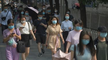 Des Chinois portent des masques de protection contre le coronavirus dans une rue de Pékin, le 28 juin 2020