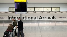 Le prêtre Alistair Macdonald (R) arrive à l'aéroport de Heathrow, le 8 juin 2020