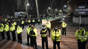 Des policiers forment un cordon à New Scotland Yard, le siège du Metropolitan Police Service, dans le centre de Londres le 14 mars 2021 alors que des londoniens manifestent, en colère après l'affaire Sarah Everard. 