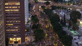 Des personnes se rassemblent pour manifester à Tel Aviv, en Israël, le 17 août 2025, exigeant que le gouvernement renonce à sa décision d'occuper entièrement la ville de Gaza et signe un accord d'échange de prisonniers.