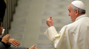 Le pape fait un signe de la main en passant dans le hall Paul VI, au Vatican, le 22 décembre 2014. Il a lundi formulé des "vœux" s'apparentant en réalité à un sévère réquisitoire contre les dérives de certains prélats. 