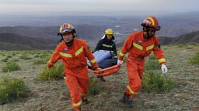 Des sauveteurs transportent du matériel pour venir en aide à des coureurs pris dans de fortes intempéries, le 22 mai 2021, près de Baiyin dans le nord-ouest de la Chine

