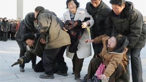 Habitants de Pyongyang apprenant la mort de leur dirigeant. Selon des témoins, les larmes de Nord-Coréens éplorés après le décès de Kim Jong-il étaient authentiques et à la hauteur de leur affection pour le président. /Photo prise le 19 décembre 2011/REUT