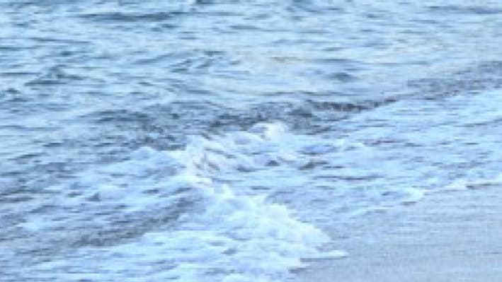 Un officier de police turc devant le corps d'Aylan Kurdi, petit réfugié syrien retrouvé mort sur une plage de Bodrum, au sud de la Turquie, le 2 septembre 2015, après le naufrage d'une embarcation.