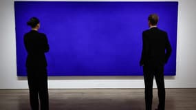 Les employés de la maison de vente aux enchères Christie's regardent un tableau intitulé "Californie" (IKB 71) de l'artiste français Yves Klein exposé à la maison de vente aux enchères Christie's à Paris, le 3 octobre 2025.