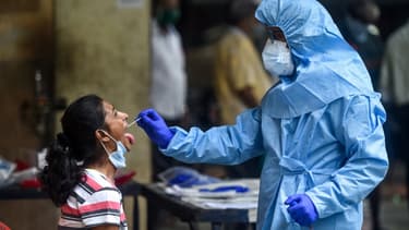 Un soignant effectue un test Covid-19 sur une habitante, à Mumbai (côte ouest de l'Inde), le 16 juillet 2020