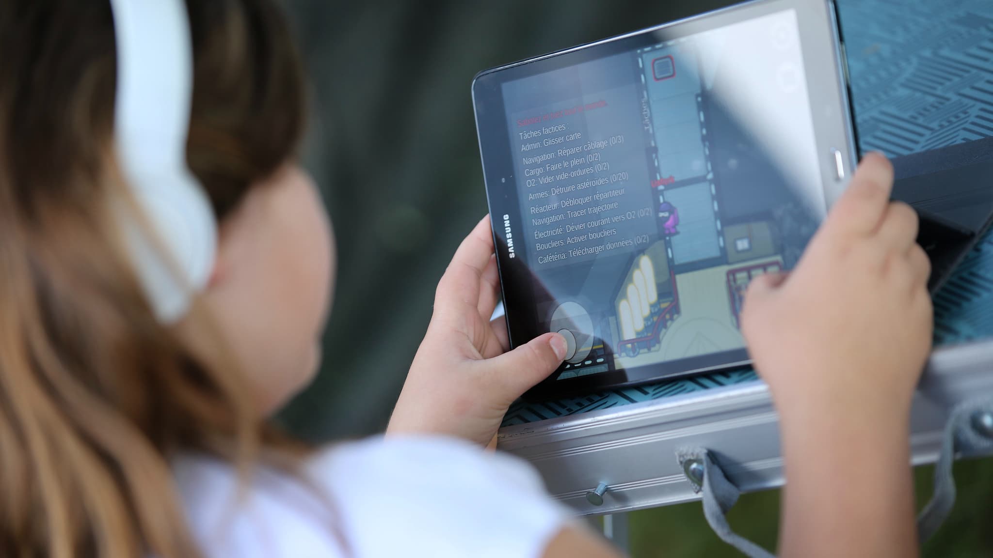 Une fillette en train de jouer à un jeu vidéo sur tablette. 