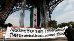 Le groupe France Syrie Démocratie, qui soutient l'opposition au régime syrien, a accroché vendredi matin sous la Tour Eiffel un immense drapeau vert, blanc et rouge frappé de trois étoiles, pour réclamer un soutien accru de la communauté internationale à