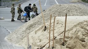 Un habitant de Kiev en train de traverser à vélo près d'un barrage anti-tank ce samedi.