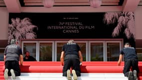 Des employés déroulent le tapis rouge pour la 74e édition du Festival de Cannes, le 6 juillet 2021