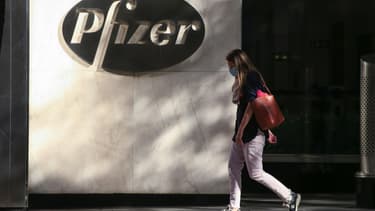 Une femme devant le siège mondial du groupe Pfizer à New York, le 9 novembre 2020