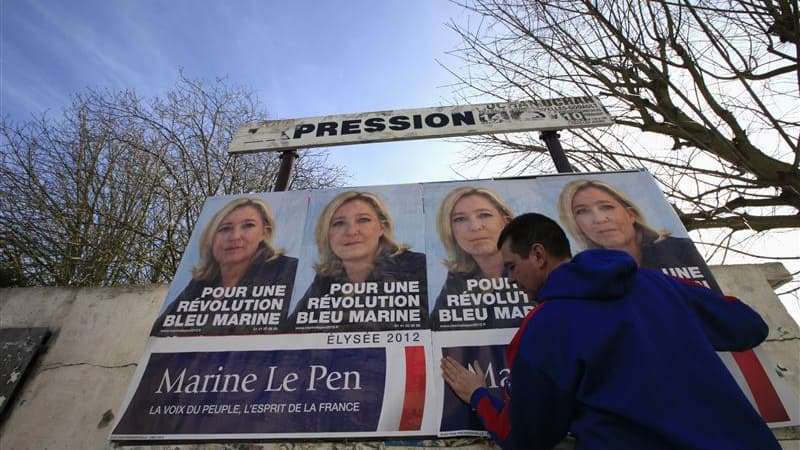 Un partisan du Front national colle des affiches de campagne de Marine Le Pen à Hénin-Beaumont. Dans cette ville de l'ancien bassin minier du Pas-de-Calais, qui sert de "laboratoire électoral" à Marine Le Pen et où s'élèvent encore des terrils, les proche