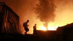 Des migrants dans le camp en feu de Moria, sur l'île grecque de Lesbos, le 9 septembre 2020