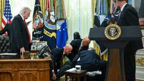 Le président américain Donald Trump observe un homme qui s'est évanoui lors d'une annonce concernant des médicaments amaigrissants dans le bureau ovale de la Maison Blanche à Washington, DC, le 6 novembre 2025.