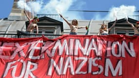 Des membres des Femen déployant une banderole sur laquelle est écrit "sextermination for nazism"