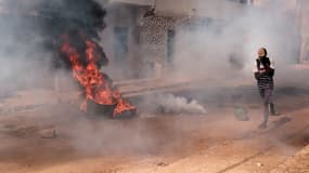 Un manifestant fuit la fumée lors de heurts entre la protestataires et forces de police, après l'annonce du report de la présidentielle, à Dakar, au Sénégal, le 9 février 2024