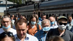 Des voyageurs portant des masques, d'autres non, en Russie, le 17 juin 2020.