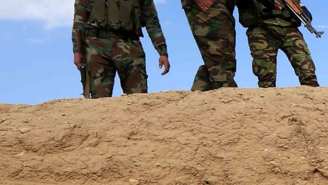 Un homme inspecte un charnier découvert par des forces kurdes en Irak,  et contenant des restes de membres de la communauté yézidie massacrés par Daesh, en février 2015.