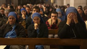 Cette photo prise le 24 décembre 2023 montre des fidèles assistant à la messe de minuit de Noël à l'église de la Nativité dans la ville biblique de Bethléem en Cisjordanie occupée.