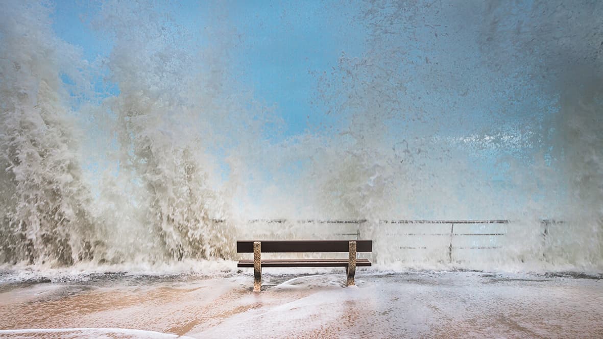 Un banc sur le point d'être submergé par une vague lors des grandes marées à Saint Malo.