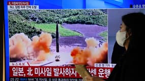 Une femme passe devant un écran montrant le lancement d'un missile nord-coréen, dans les rues de Séoul. 