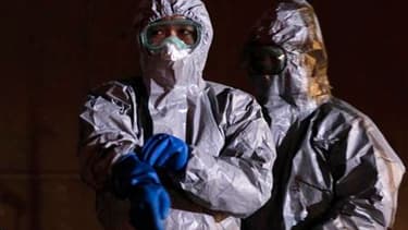 Responsables japonais en tenue anti-contamination non loin de la centrale de Fukushima.