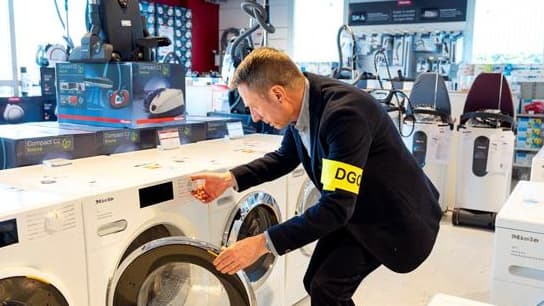 Un agent de la DGCCRF contrôle un lave linge.