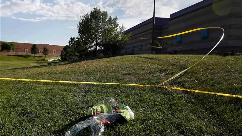 Devant le cinéma de la banlieue de Denver, où un homme masqué a tué par balles douze personnes et en a blessé 58 autres, dont des enfants, vendredi en pleine projection du dernier volet de la série Batman. /Photo prise le 20 juillet 2012/REUTERS/Shannon S