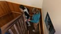 Amandine monte l'escalier de sa maison, aidé de sa maman