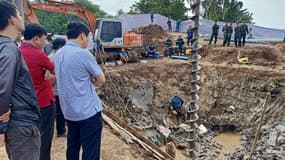 Des sauveteurs sur le site où un garçon de 10 ans est censé être piégé dans un puits de 35 mètres de profondeur dans une zone de construction d'un pont dans la province de Dong Thap au Vietnam, le 2 janvier 2023.