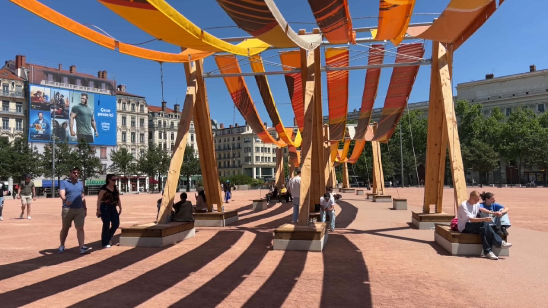 La place Bellecour, sous la chaleur le 25 juin 2025, avec l'œuvre anti chaleur Tissages urbains.