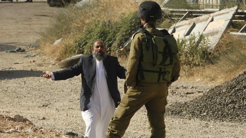Un Palestinien tente de négocier avec un soldat israélien pour traverser le blocage à la frontière entre Hébron et Yatta. (Photo d'illustration)