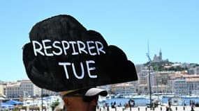 Un manifestant avec une pancarte "Respirer tue" lors d'une manifestation contre la pollution de l'air à Marseille, le 11 juin 2022