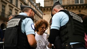 Des gendarmes avec une spectatrice avant la cérémonie d'ouverture des Jeux olympiques près du musée du Louvre, le 26 juillet 2024.