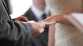 Un couple en train de se passer la bague au doigt (Photo d'illustration).