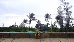 Un garçon tient un parapluie au passage du cyclone Mocha à Teknaf, au Bangladesh, le 14 mai 2023