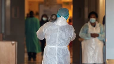 Un agent hospitalier sud-africain transporte une bonbonne d'oxygène à l'hôpital de Khayelitsha, en Afrique du sud, le 29 décembre 2020 
 