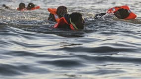 Des migrants nagent alors qu'ils tentent de monter à bord d'un bateau de passeurs pour traverser la Manche au large de la plage de Gravelines, le 16 juin 2025 dans le Nord. (Illustration)