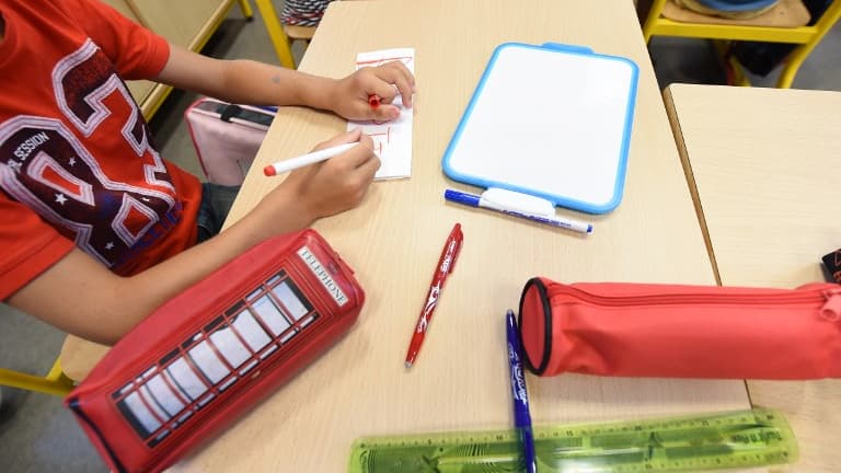 Un enfant écrit son nom sur un bout de papier lors de la rentrée des classes (image d'illustration)