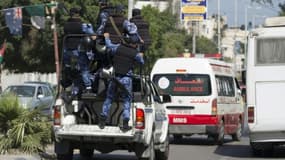 Des policiers du Hamas escortent une ambulance transportant les corps de trois hommes pendus, accusés de collaboration avec Israël, le 6 avril 2017 à Gaza